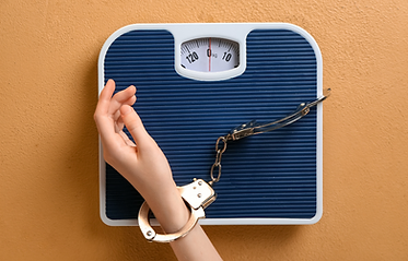 Image of a hand handcuffed to a scale, illustrating that people with anorexia often also display obsessive-compulsive disorder (OCD) symptoms.