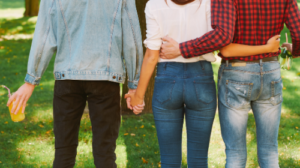 A woman holding the hand of one man with her other arm around another man. Healing Path Therapy provides expert therapy for couples and relationships.