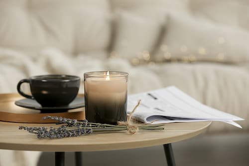 Closeup of a small round table with a lit candle, a tea cup, and a bunch of lavender illustrating that Healing Path Therapy offers online, compassionate, effective therapy for couples, anxiety, LGBTQ+ related issues, and more.