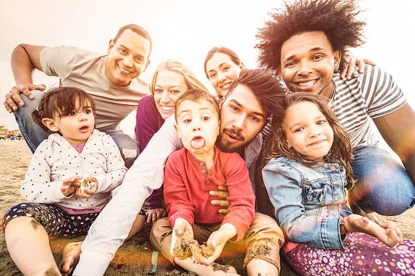 Large, happy, multiracial family, illustrating the concept that our family therapy services are designed to support families in navigating a wide range of challenges and transitions.