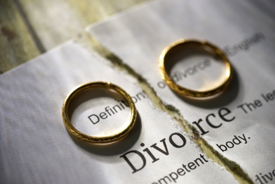 Image of a torn paper with the word, "divorce" and two wedding rings, one on each side, illustrating the concept that the support and compassion of one of our therapists can help you work through this difficult transition.